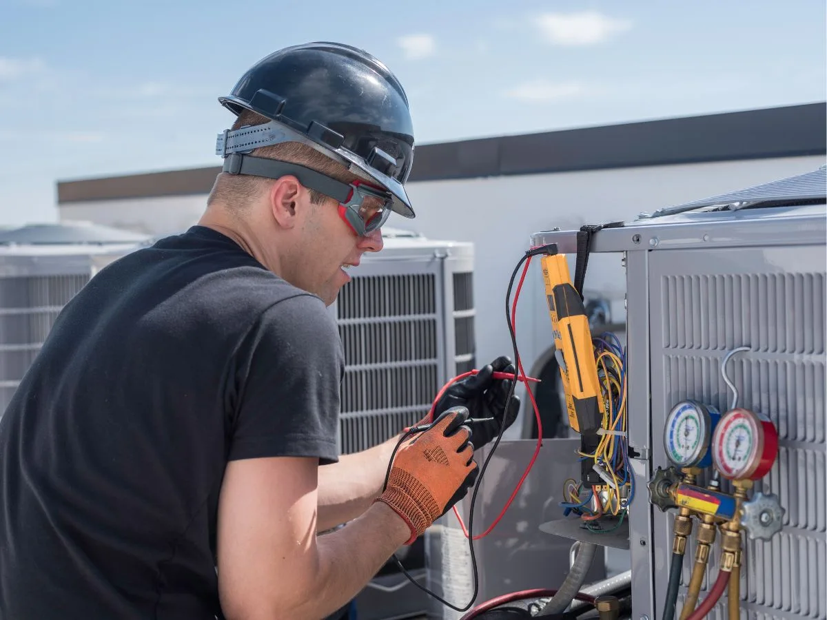 a man repairing a hvac system with specialised equipment